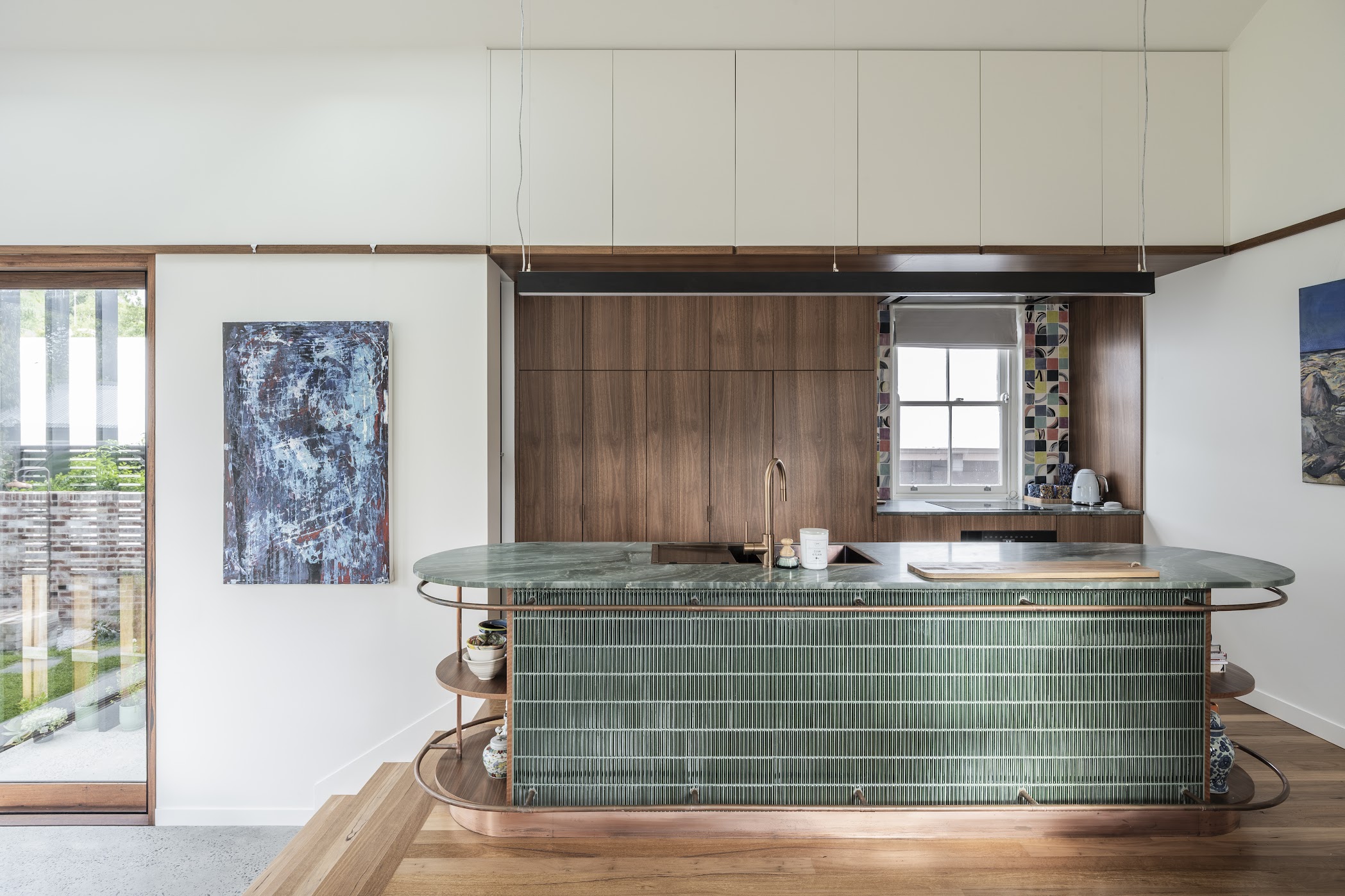 Kitchen island — green finger tiles with copper frame, green marble top, walnut cabinetry behind