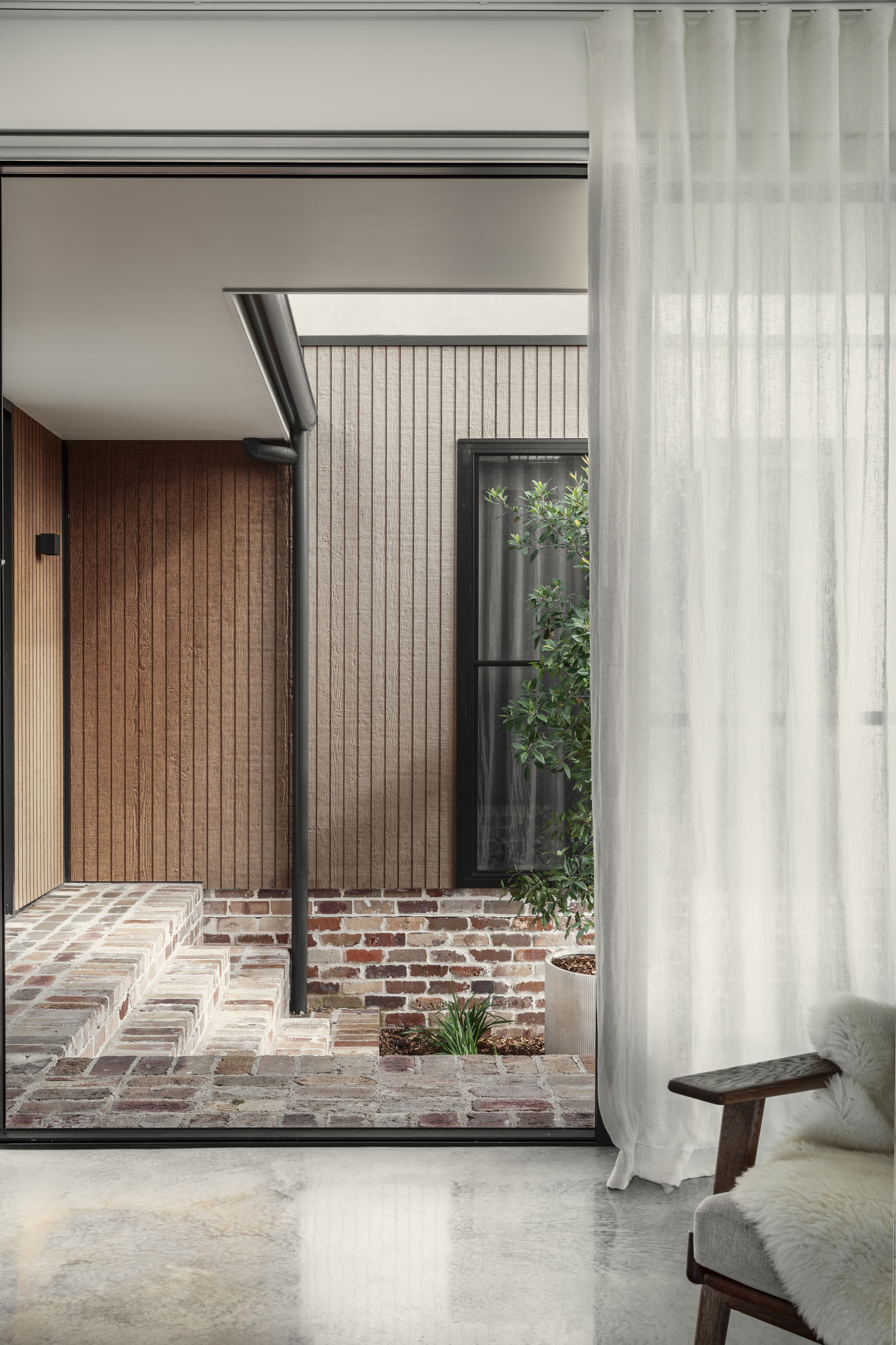 Multi-Gen House exterior — timber cladding, black steel fence, two-storey facade