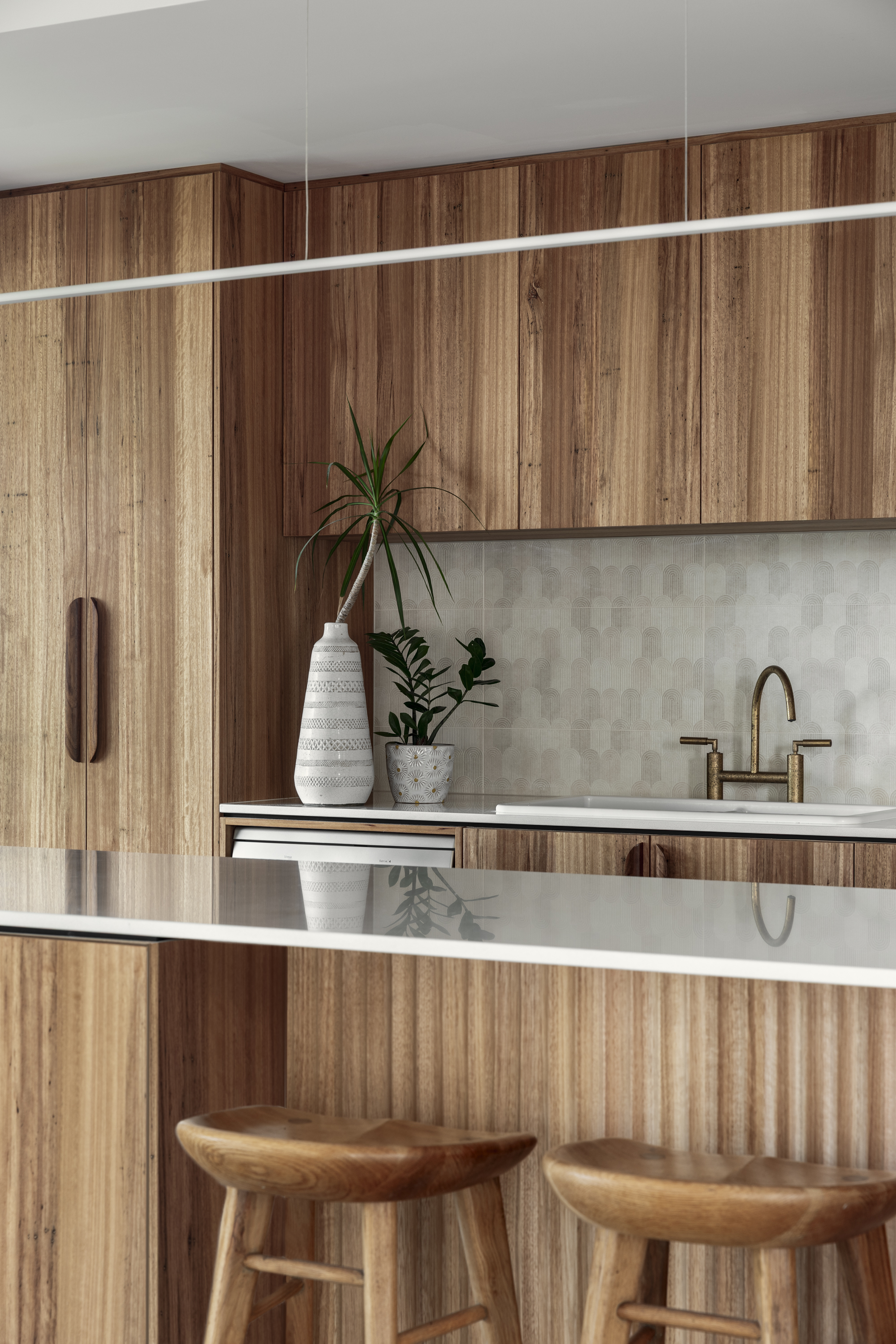 Custom timber kitchen with brass fixtures and tile splashback